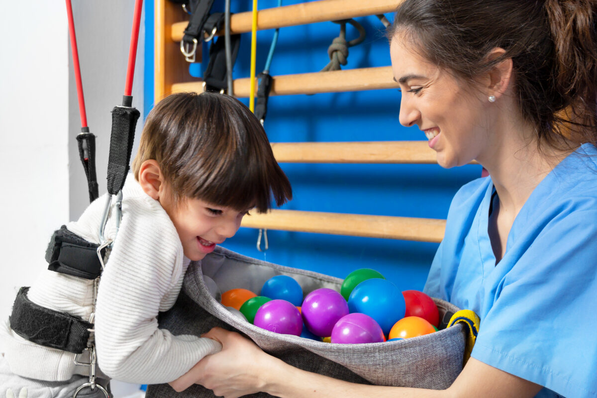 Cute kid with cerebral palsy doing musculoskeletal therapy in the hospital while laughing and having fun . Occupational therapy is a powerful tool that can help people with disabilities live more independent and fulfilling lives.