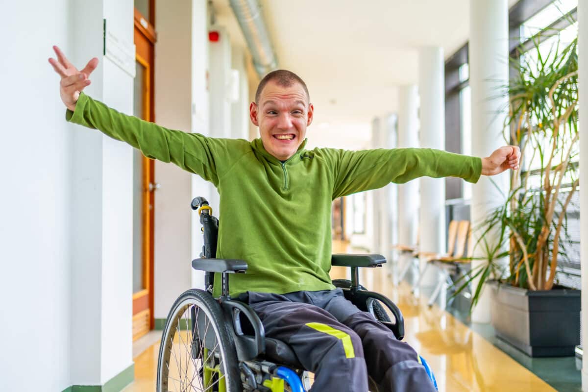 Man with cerebral palsy celebrating he is in the university Occupational therapy session Bloom Healthcare